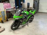 a green motorcycle that is parked in a garage