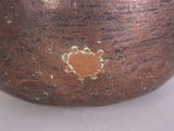 a close up of a brown vase with a flower on it
