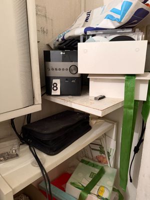 un petit placard dont les étagères sont bien remplies