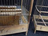 two wooden cages with metal bars on each of them