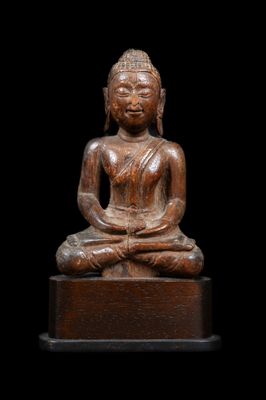 une statue en bois représentant un Bouddha assis sur une surface noire