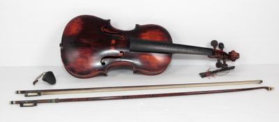 un vieux violon est posé sur une surface blanche, à côté d'un archet