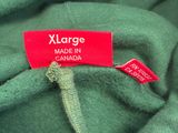 L'étiquette se trouve sur un t-shirt vert portant l'inscription « XXL » et « Made in Canada ».
