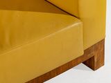 yellow leather couch with wooden legs and a white background