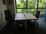 un bureau avec deux chaises devant une grande fenêtre