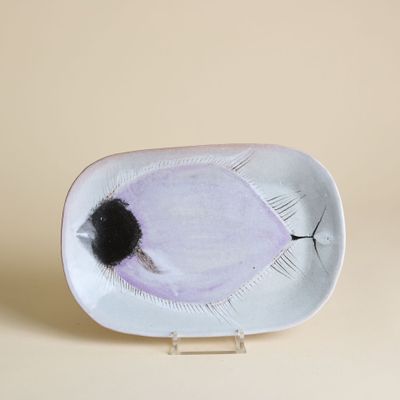 une assiette blanche sur laquelle est dessiné un œil noir
