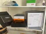 une étagère blanche sur laquelle se trouvent un ordinateur et une boîte