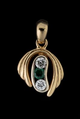 un gros plan d'un pendentif en or orné d'une pierre verte et blanche