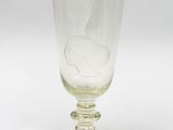 un verre sur lequel repose une feuille, posé sur une table