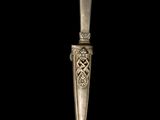 a close up of a silver spoon on a black background