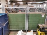 a large metal gate in a warehouse with a green wall behind it