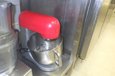 un mixeur rouge posé sur un plan de travail en inox