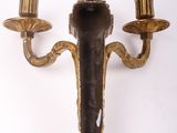 a wall mounted candle holder with two candles on it