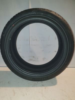 a close up of a tire on a white surface with a white wall in the background