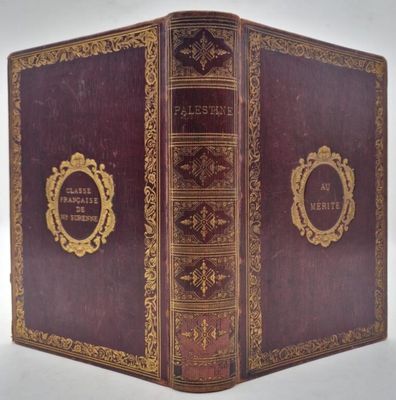 an old leather book with gold trimming and a picture frame on the cover