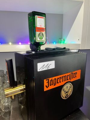 un petit réfrigérateur noir sur lequel est posée une bouteille de bière