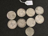 several silver coins are arranged in a triangle on a black surface