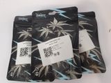 three bags of cannabis seeds sitting on top of a white table