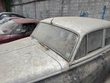 two old cars parked next to each other in a parking lot