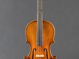 an old violin sitting on a stand against a gray background