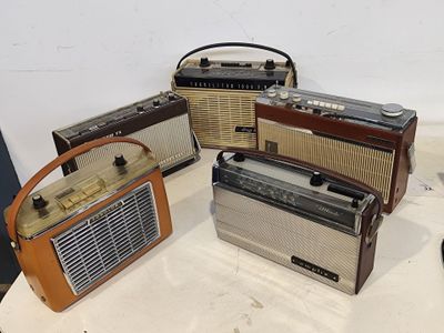 quatre vieilles radios posées les unes à côté des autres sur une table