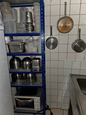 de nombreuses casseroles et poêles sur les étagères de la cuisine