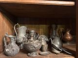 many silver vases on a shelf in a wooden cabinet