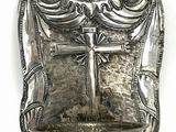 an antique silver plate with a cross on it on a white background