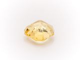 a close up of a yellow diamond on a white surface