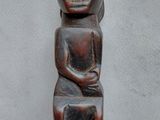 an image of a statue of a person sitting on top of a wooden block