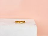 une bague en or posée sur un bloc de marbre blanc