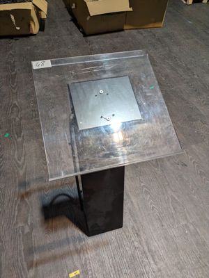 une table avec un plateau en verre posée sur un parquet