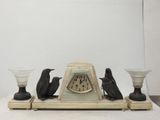une horloge posée sur une table avec deux bougies