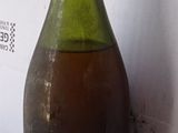 a bottle of wine sitting on a counter next to a wall