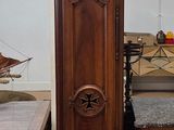 une horloge de parquet au milieu d'une pièce, à côté d'un canapé