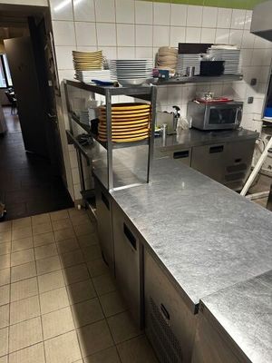 un plan de travail en acier inoxydable dans une cuisine professionnelle, sur lequel sont posés de nombreux plats
