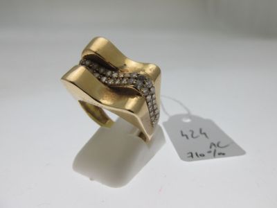 une image d'une bague en or et en diamant sur une surface blanche