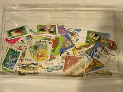 a clear box filled with postage stamps on a table