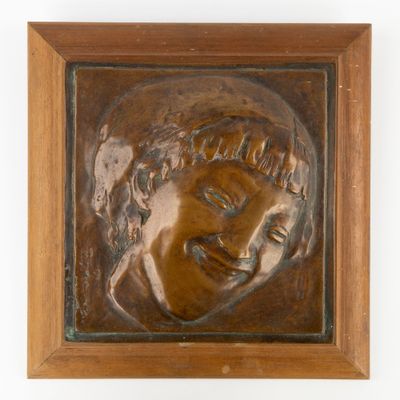 un gros plan sur une plaque en bronze représentant le visage d'un homme