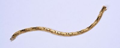 un serpent doré allongé sur une surface blanche