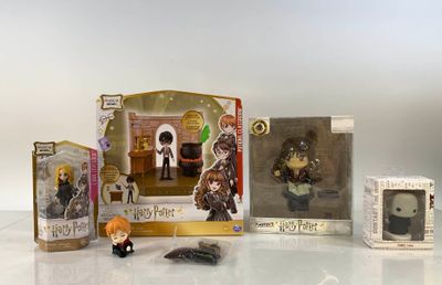 Des figurines Harry Potter sont exposées sur une surface blanche