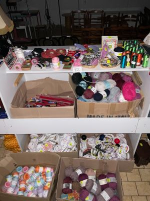 de nombreuses boîtes de laine et de crochets posées sur une table