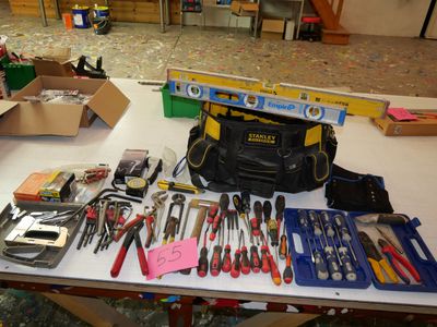 une table sur laquelle se trouvent de nombreux outils et un sac posé dessus