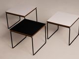 three small tables with black and white tops sit on a white surface