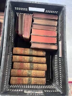 many old books in a basket on the table