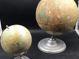 two old globes are sitting on top of each other on a table
