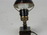 an image of a black and gold lamp on a white surface