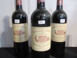 Trois bouteilles de vin sont alignées sur une table noire