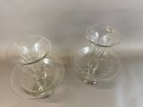 two glass vases sitting on a table next to each other