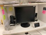 a computer desk with a monitor and speakers on it
